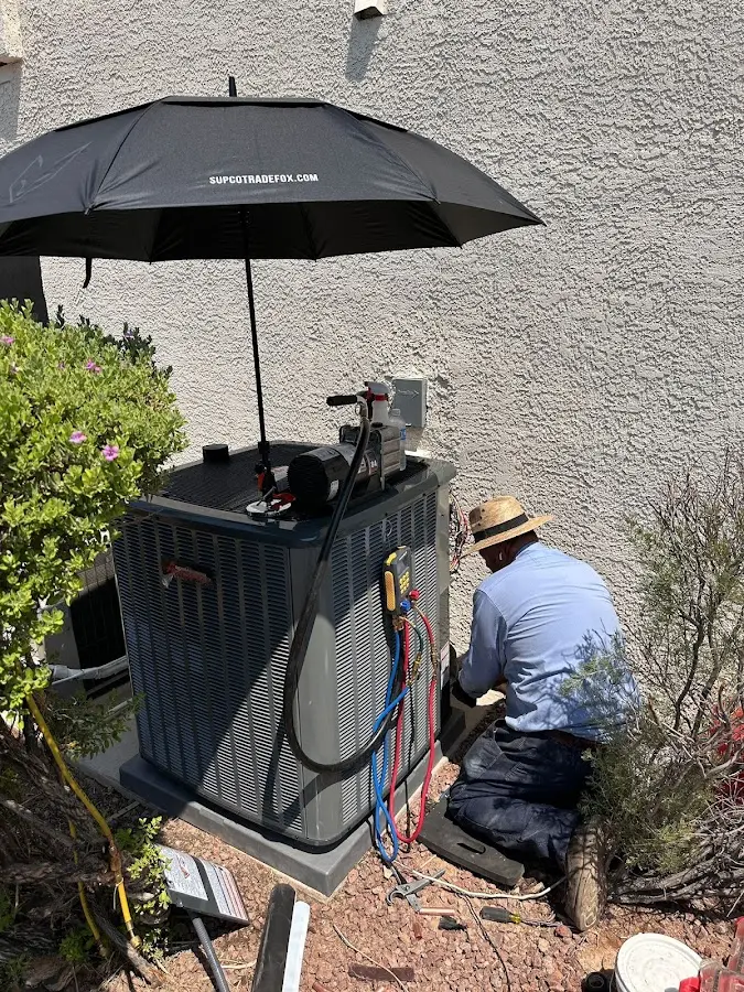 HVAC technician performing outdoor AC maintenance in Villas