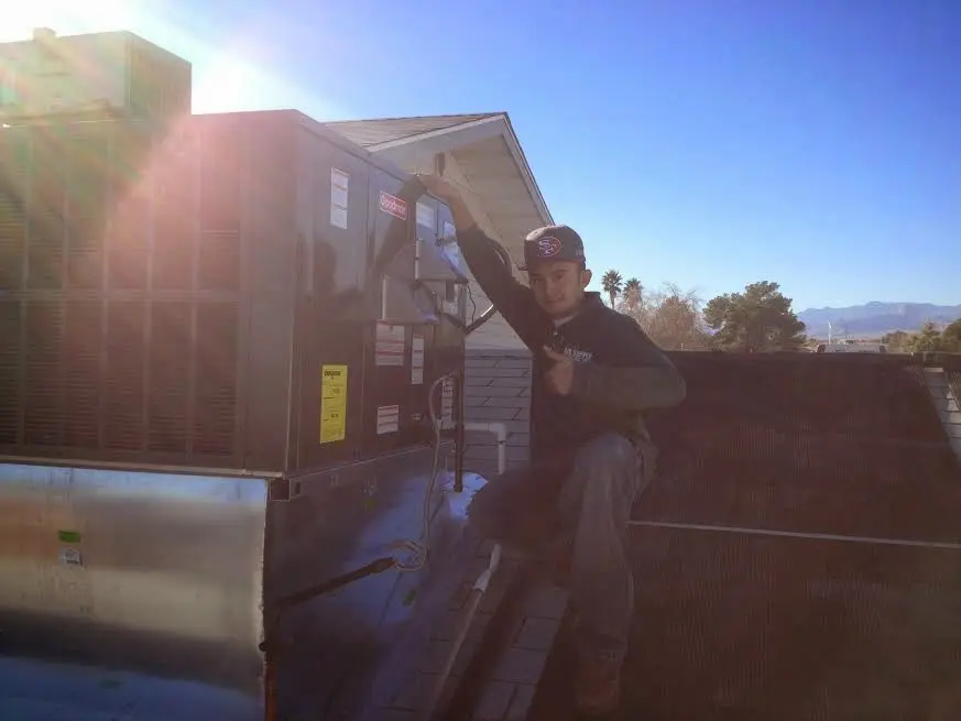 HVAC technician performing HVAC Inspection on a rooftop unit in Villas